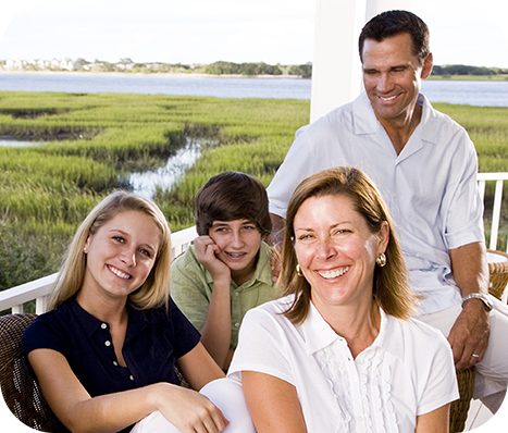 family of 4 enjoying their balcony overlooking marsh land