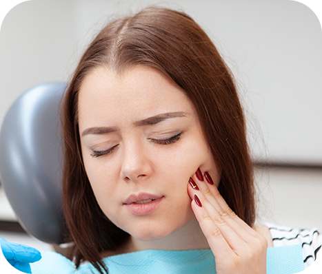 patient sitting in the dental chair feeling her jaw will her dentist is close by