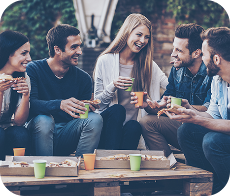 Five friends enjoying pizza and drinks outside
