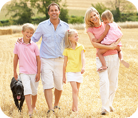 family of 5 and their dog walking in rolling fields